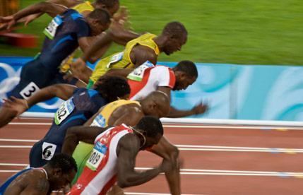 Close-up of runners starting a sprint race on a track.