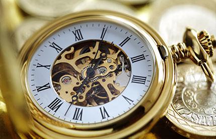 Close-up of a gold pocket watch with visible gears, symbolizing the Investment Clock.