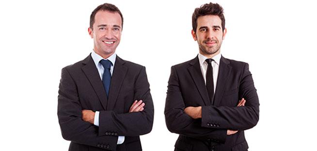 Two professional businessmen in suits with arms crossed.