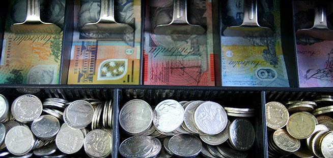 Close-up of a cash register with Australian dollar notes and coins.