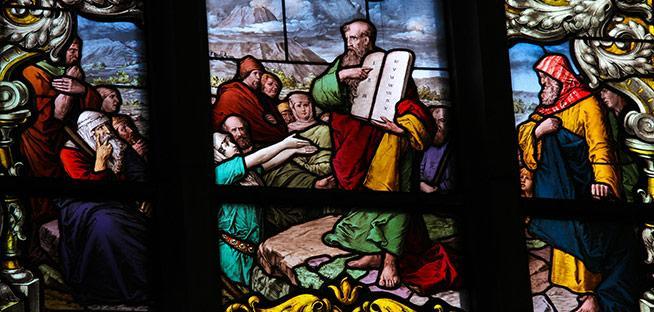 Stained glass art depicting Moses holding the Ten Commandments.