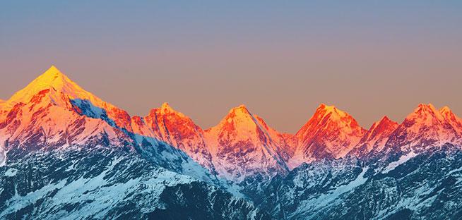 Snow-capped mountains under a colorful sunset.
