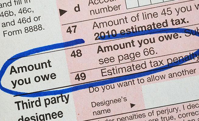 Close-up of a tax form with "Amount you owe" circled in blue ink.