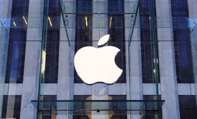 Large white Apple logo on the glass exterior of a retail store building.