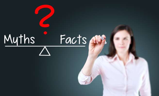 Woman drawing a balance scale where "Myths" outweighs "Facts" under a question mark.