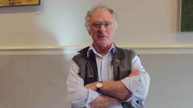 Man named James from Tasmania seated at a table looking thoughtful.