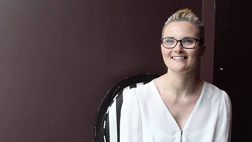Blonde woman named Renae G with glasses, hair in a bun, smiling in a white v-neck blouse.