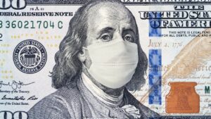 A close-up image of the $100 US dollar bill with Benjamin Franklin wearing a white surgical face mask, symbolizing economic or health concerns.